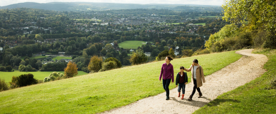 Two women and child walking along a path with wide panorama