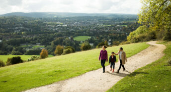 Two women and child walking along a path with wide panorama