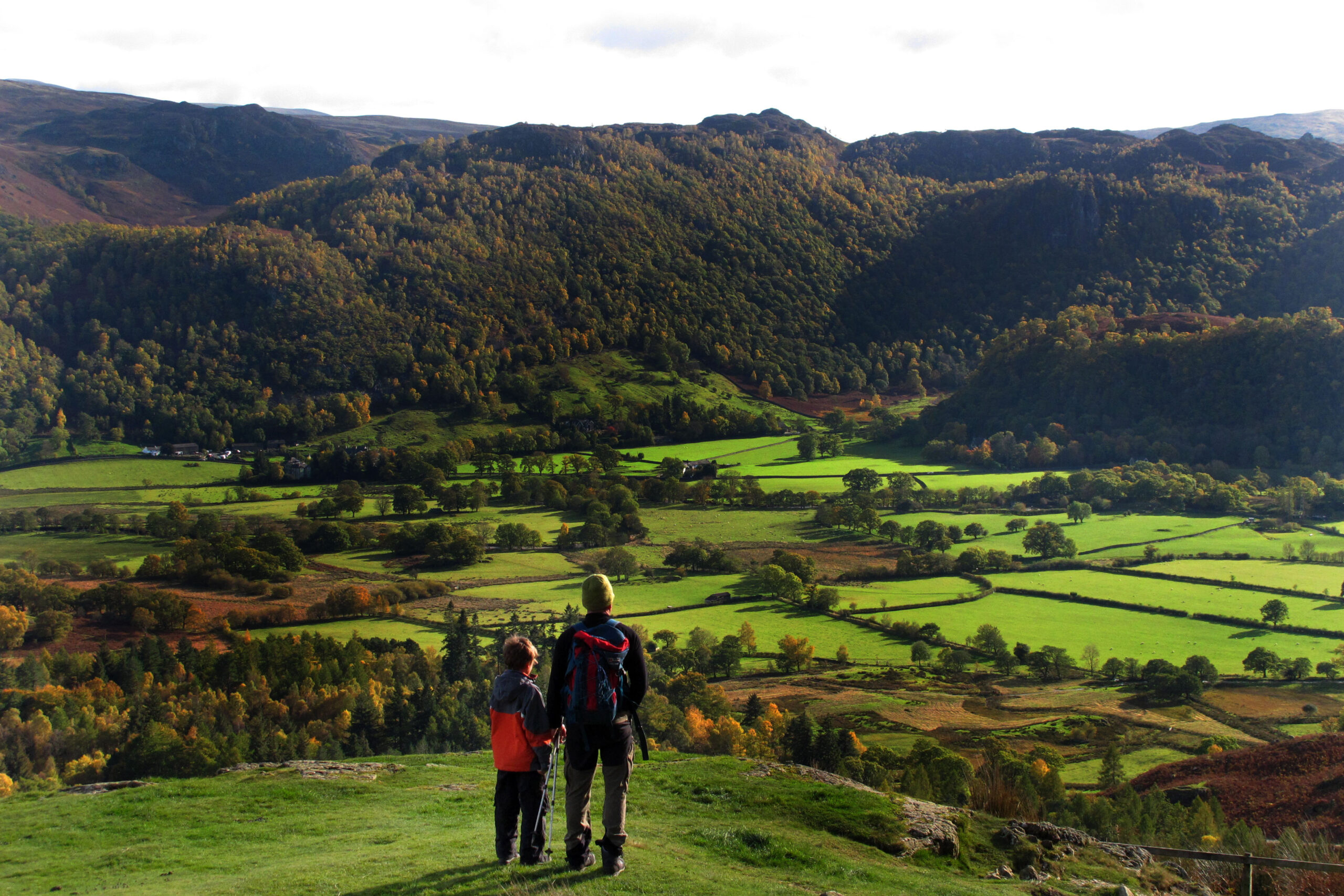 A Father and son admire the view while rambling in the Lake District, Cumbria.