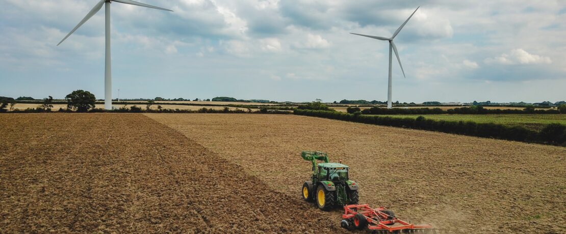 Farm with wind turbines in the distance