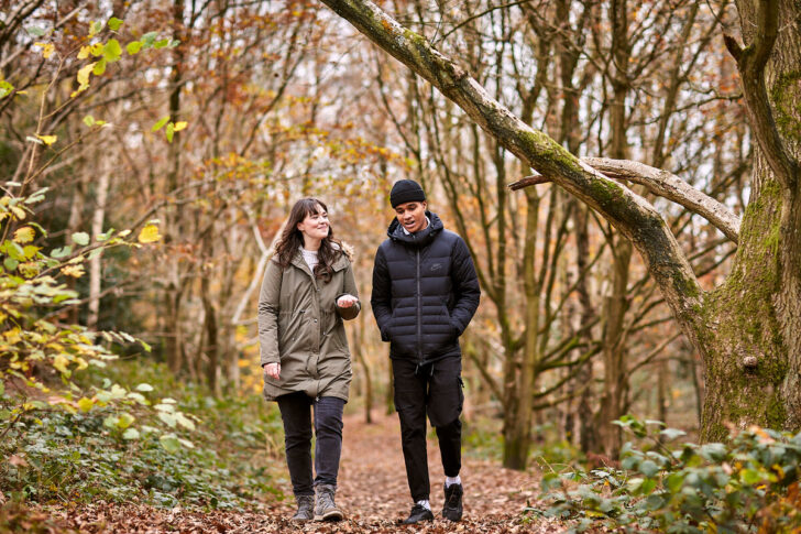 Woman and man walking and talking in woodland