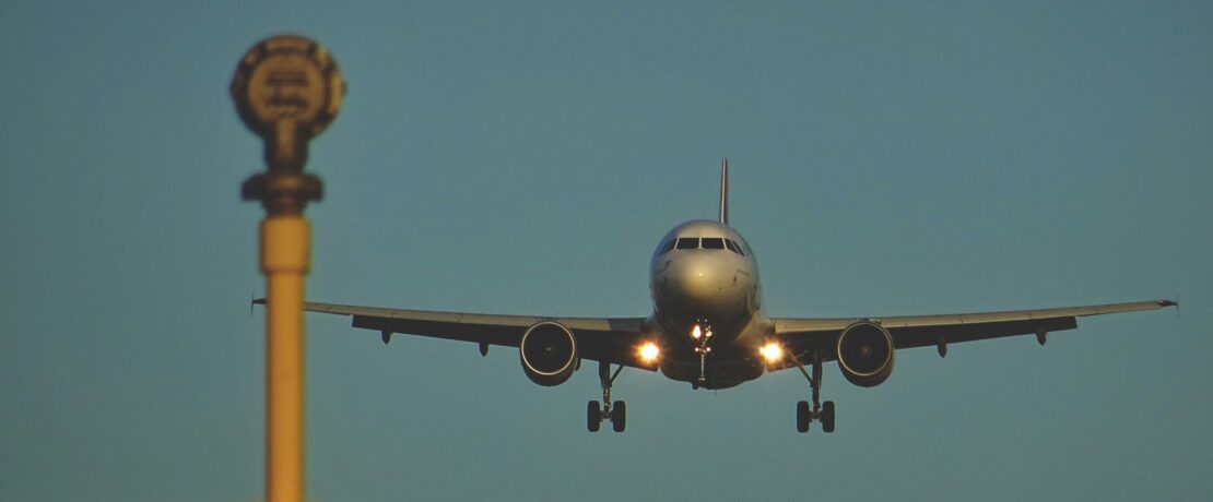 Flying airplane approaching runway signal light