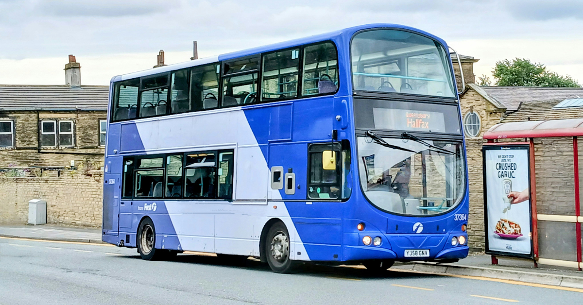 A blue bus near a bus stop in a suburban area