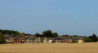 green grass field with houses during daytime