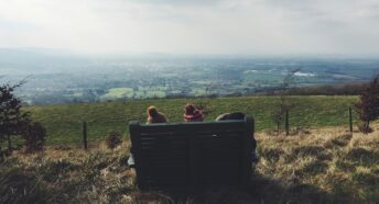 Two children sitting on bench looking at the landscape views
