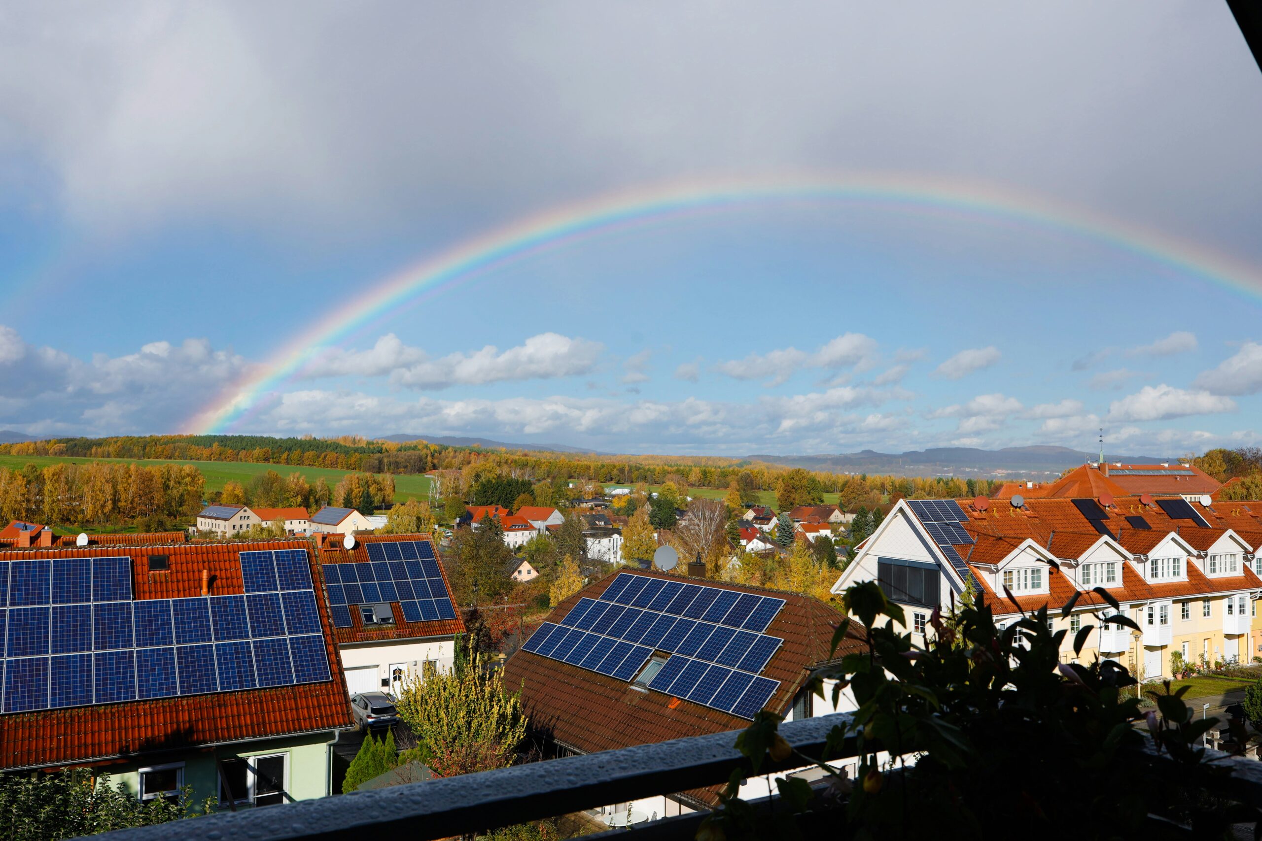 Rooftop solar on homes with rainbow above