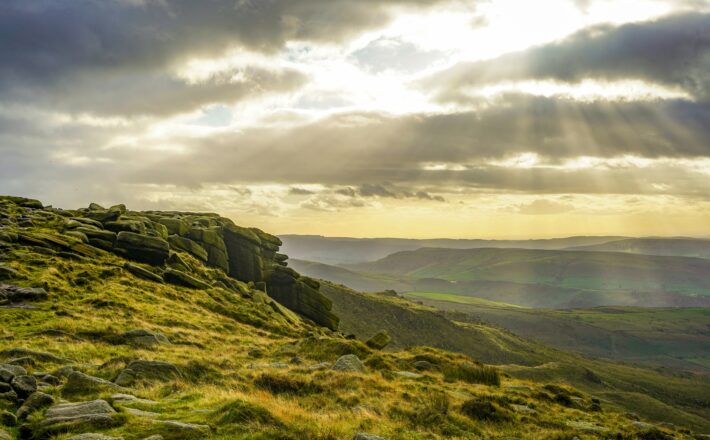 the sun shines through the clouds over the mountains