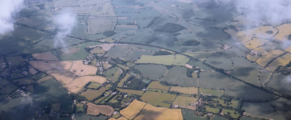 An aerial view of a field with clouds in the sky