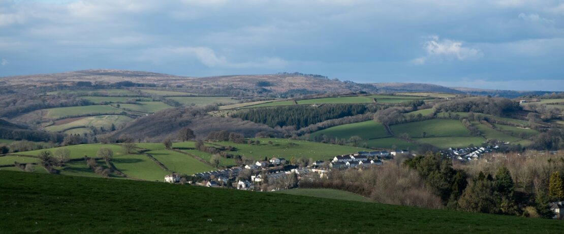 green fields and a small town under cloudy skies