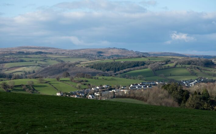 green fields and a small town under cloudy skies