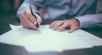 A close-up of a man signing a document