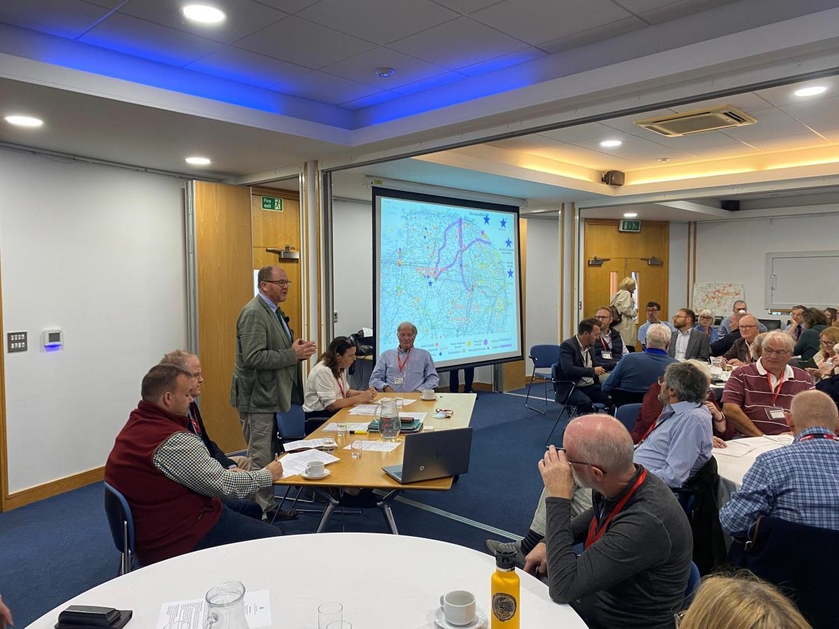 George Freeman MP chairing the solar summit with a large number of attendees in the audience